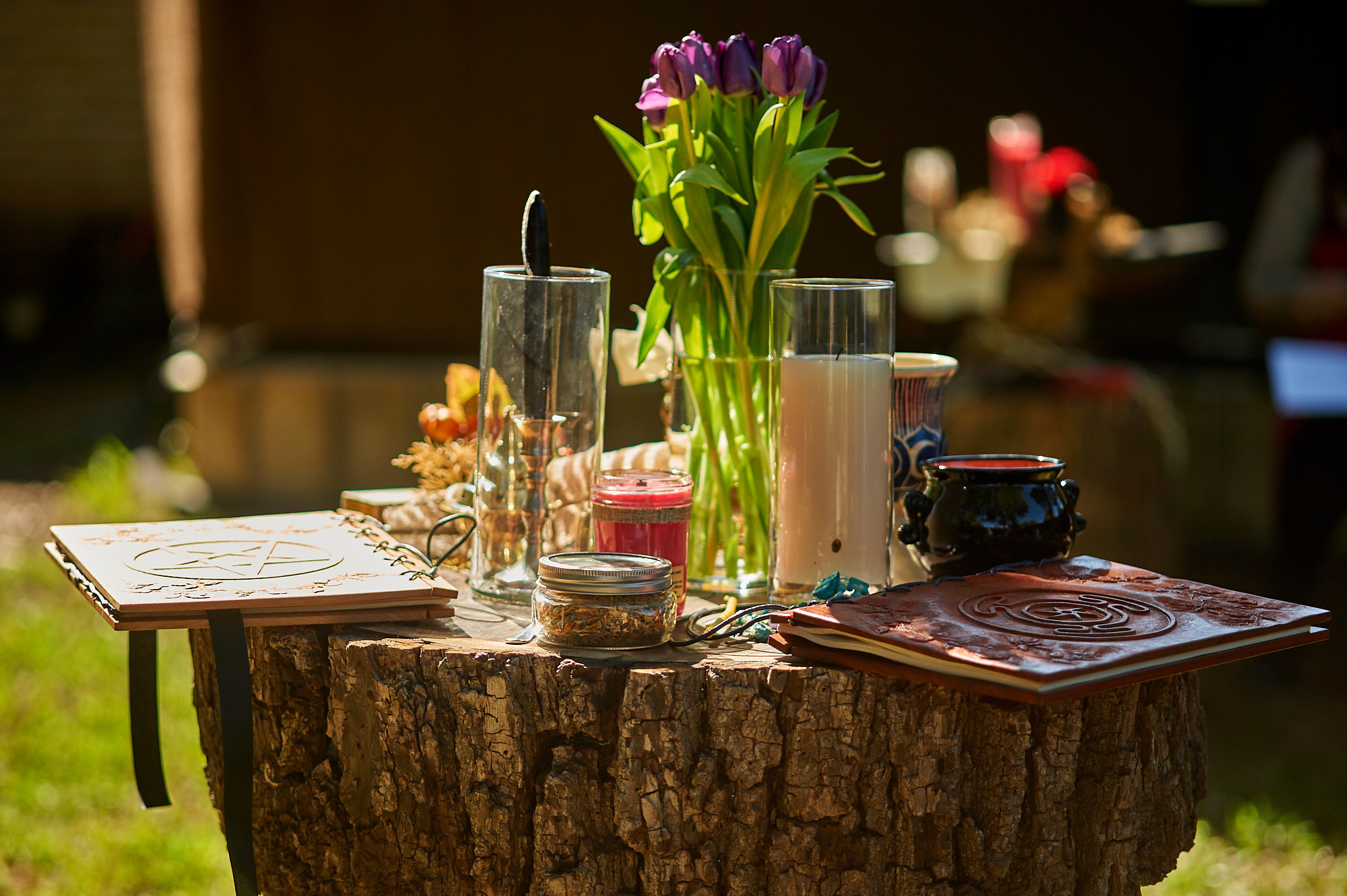 Altar from Samhain Ritual,Vase of Purple Tulips, candles, cauldron all on a wooden table